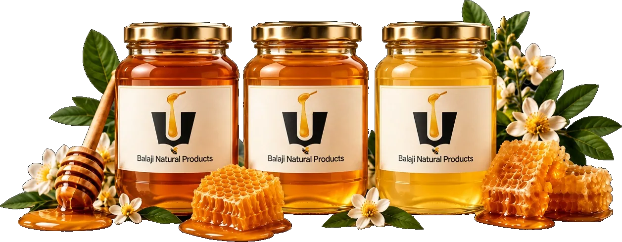 Three jars of Balaji Natural honey with a wooden dipper, honeycomb, and white blossoms